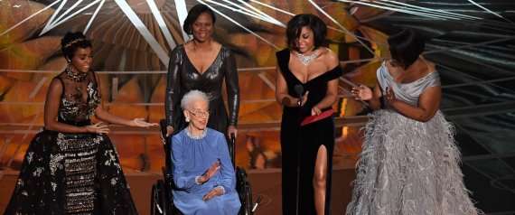 NASA physicist Katherine Johnson (C) is surrounded by US singer and actress Janelle Monae (L), US actress Taraji P. Henson (2ndR) and US actress Octavia Spencer (R) as they present on stage the Best Documentary Feature award at the 89th Oscars on February 26, 2017 in Hollywood, California. / AFP PHOTO / Mark RALSTON