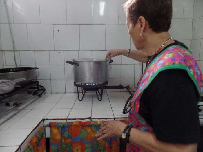 La señora Cándida también ayuda a preparar el almuerzo de los chiquitos