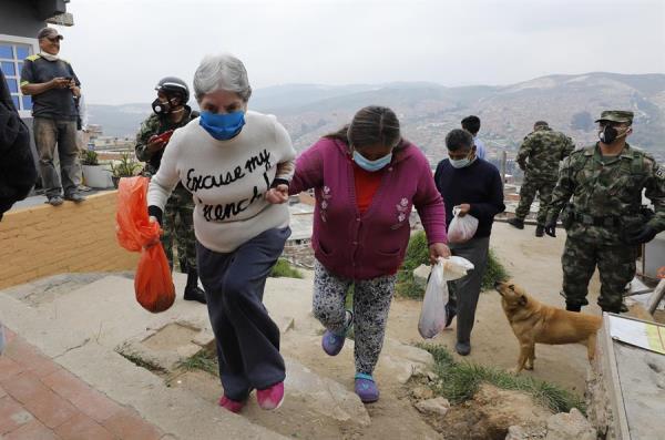 Militares colombianos suministran alimentos a pobladores de la localida Soacha, el 30 de marzo