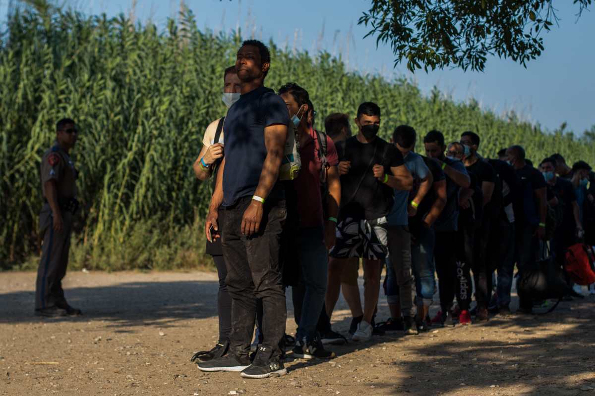 Luego de identificarse con las autoridades, este grupo de migrantes venezolanos espera en fila para su traslado a un centro de procesamiento de ICE