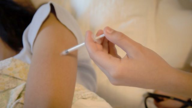 Una mujer recibe una vacuna