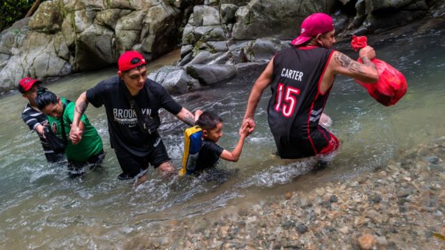 Migrantes cruzando el Darién.