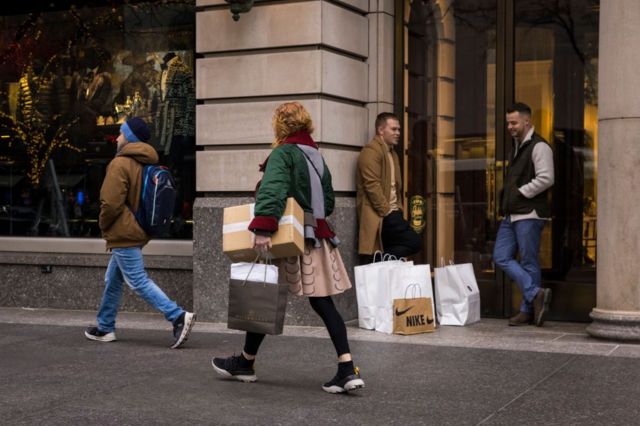Personas con paquetes y bolsas de compras.